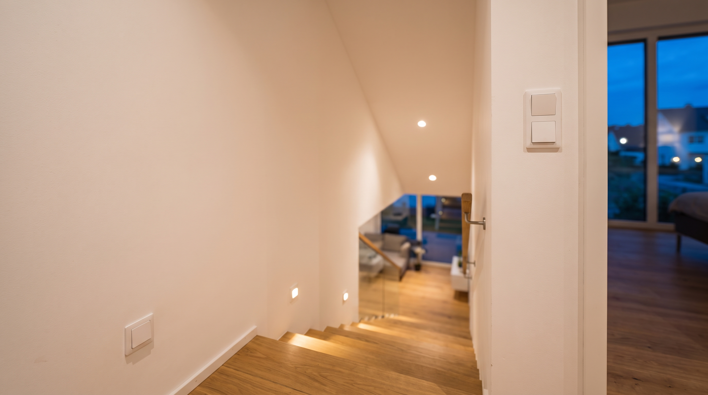 Treppenhaus mit Lichtschaltern auf mehreren Ebenen und eingeschalteter Stufenbeleuchtung